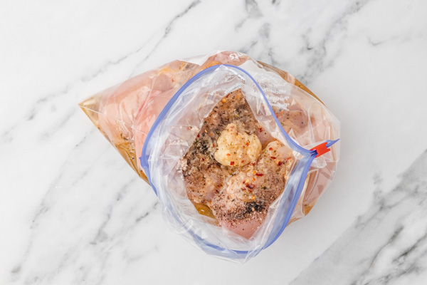 marinade and chicken in a ziploc bag about to be seasled.