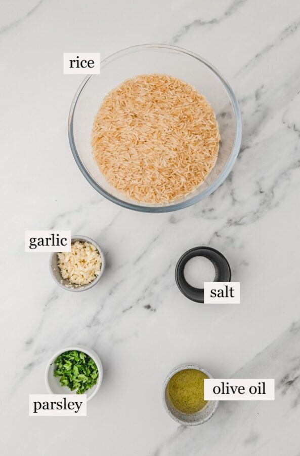 ingredients to make garlic rice on a marble surface.