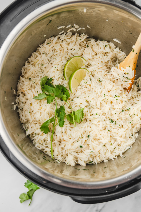cooked white rice in an instant pot with woodle ladle.