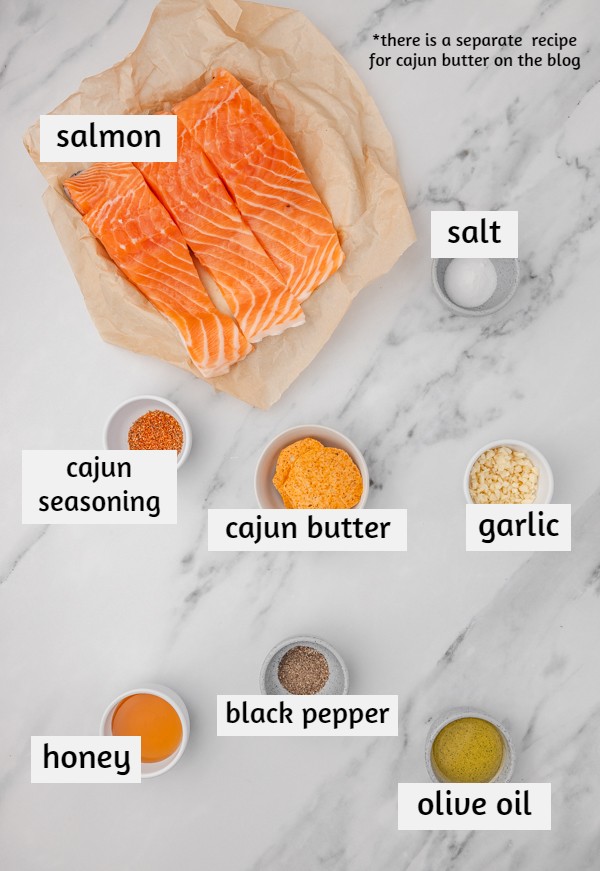 ingredients to make cajun butter salmon on white marbles surface.