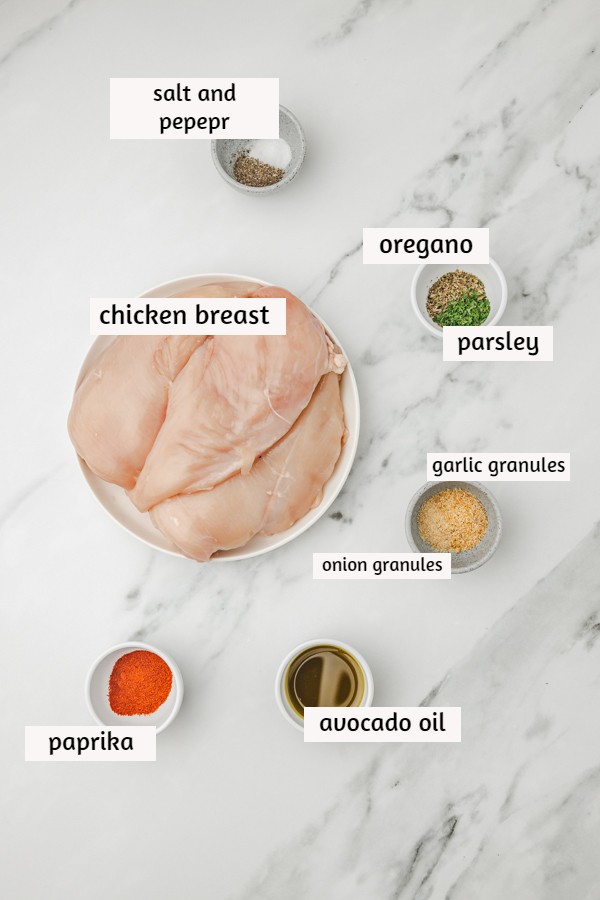 ingredients needed for chicken breast on a white marble surface.