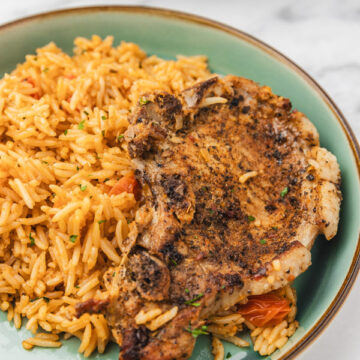 a plate of pork chops and tomato rice.