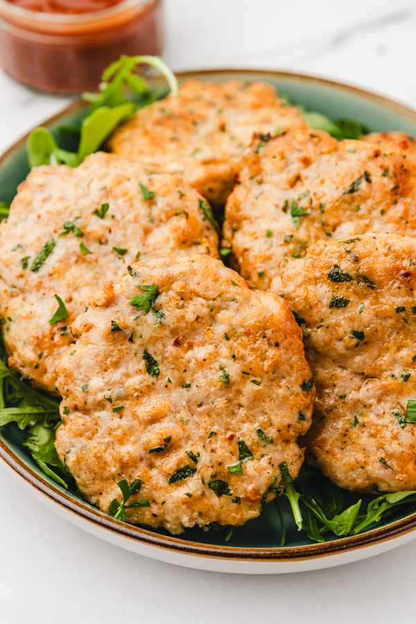 chicken patties on a bed of rocket salad.