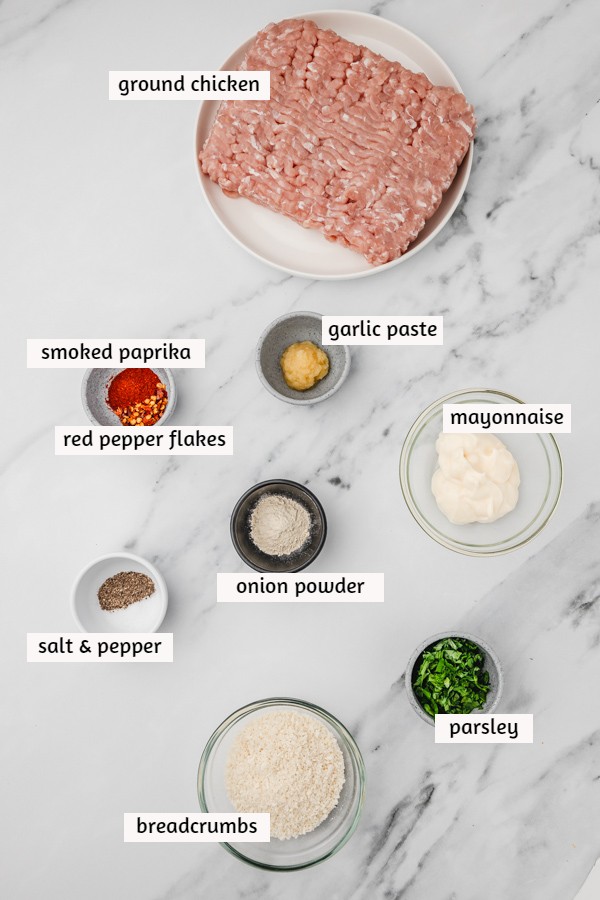 ingredients for chicken mince burger on a white surface.