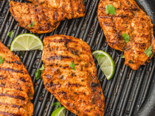 pan grilled Mexican chicken with lime wedges.