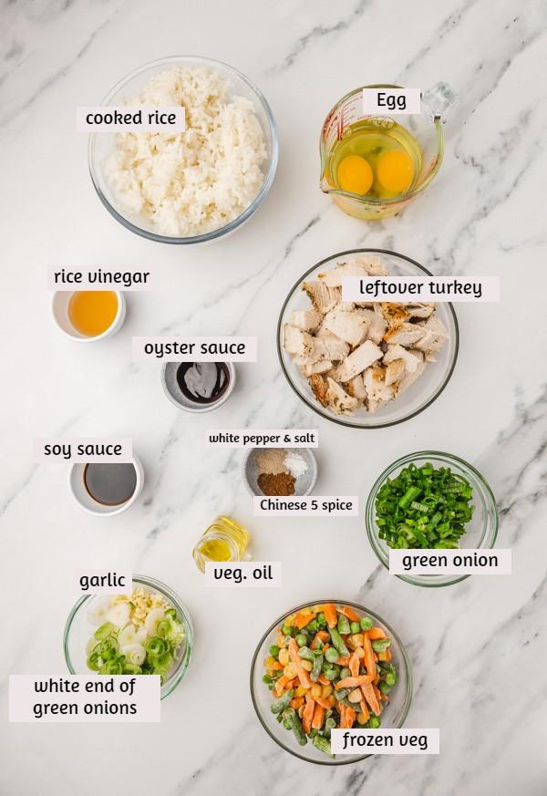 the ingredients for turkey fried rice placed on a marble surface.