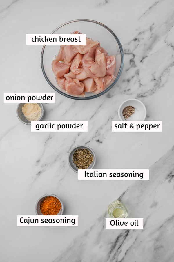 ingredients to cook chicken bites laid on a white marble surface.