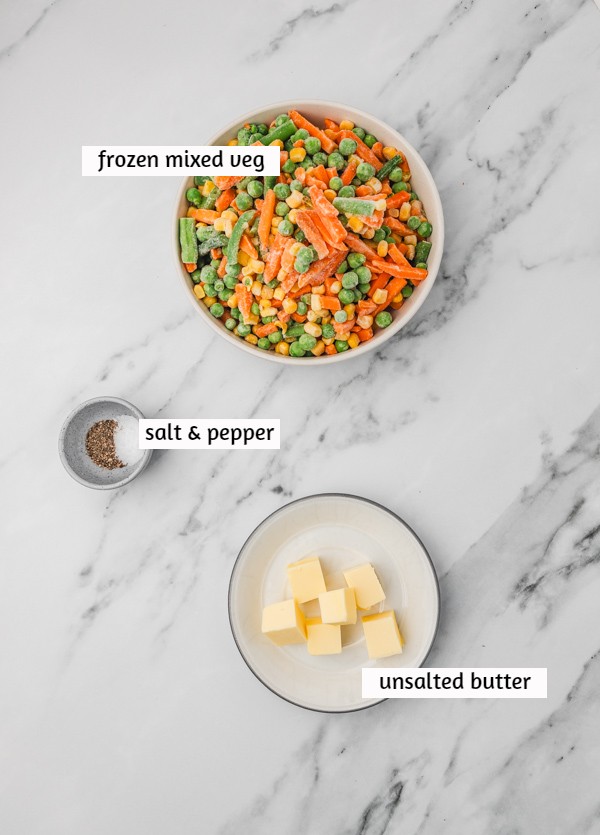 ingredients to cook frozen mixed vegetables laid on a white marble surface.