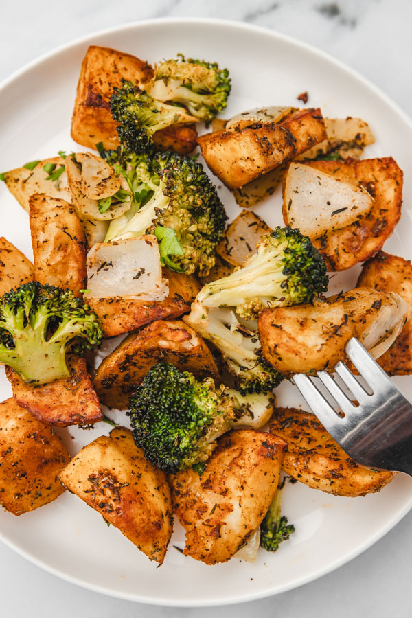 potato and broccoli floret on a fork.