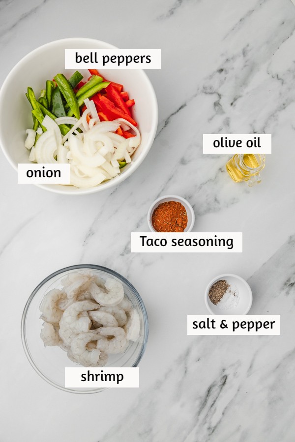 the ingredients for shrimp fajitas on a marble surface.