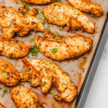 baked chicken tenders on a parchment paper lined baking sheet.