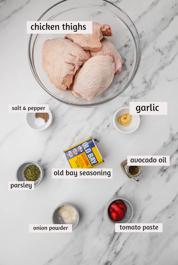old bay chicken ingredients laid on a white marble surface.