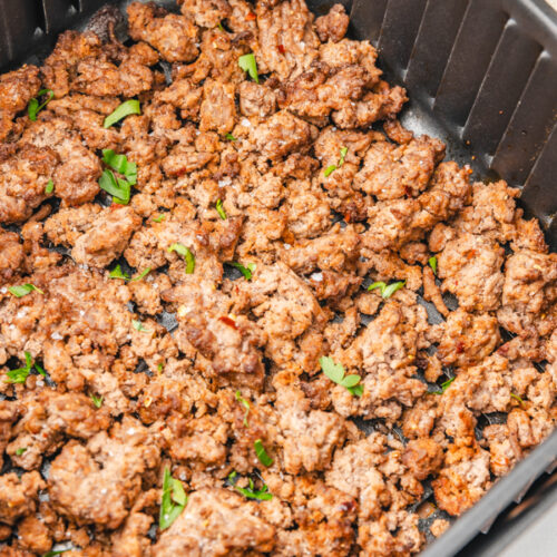 cooked ground beef in air fryer basket.