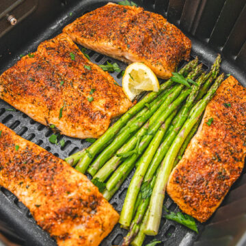 salmon and asparagus in an air fryer basket.