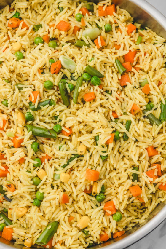 a close up of mixed vegetable rice in a skillet.