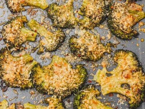 crispy smashed broccoli with parmesan cheese in a baking tray.