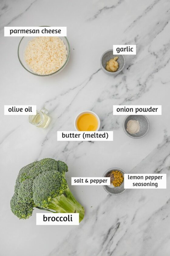 ingredients needed to make roasted broccoli on a white marble surface.
