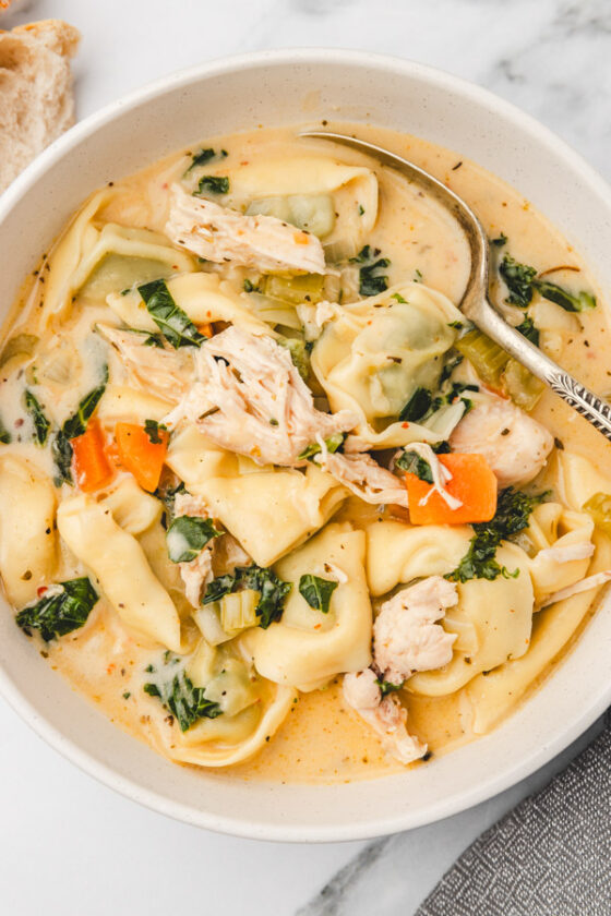 a bowl of creamy chicken soup with kale. 