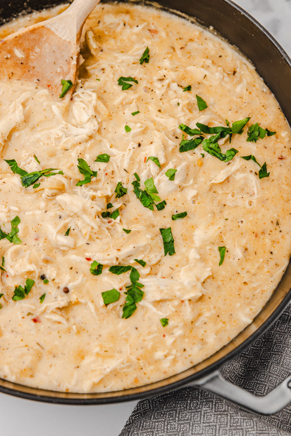 chicken gravy garnished with chopped parsley in a skillet.