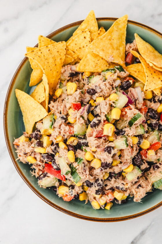 a plate of mexican tuna salad and tortilla chips.